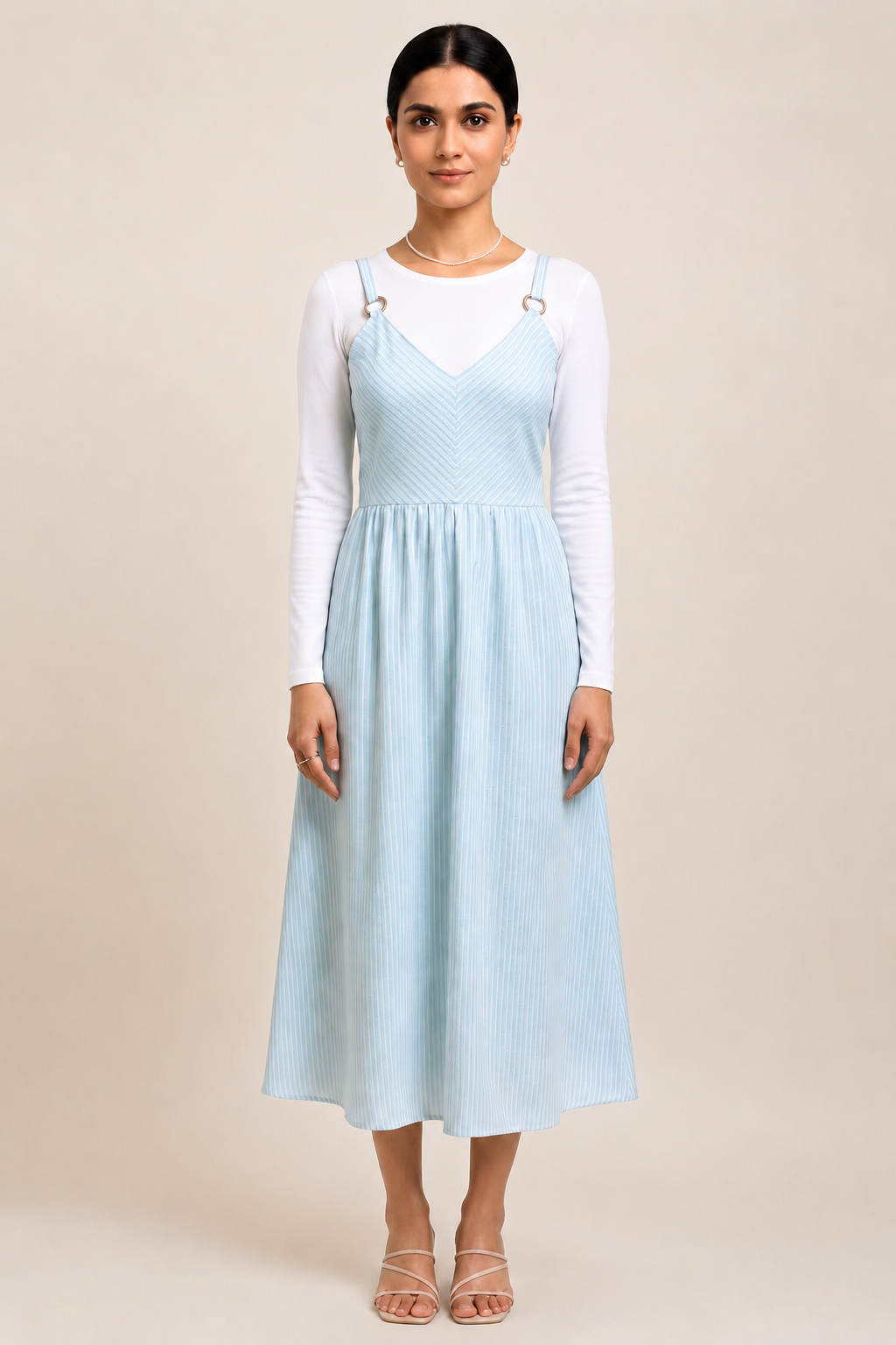 Model wearing a light blue and white striped midi sundress with ring straps and a V-neck.