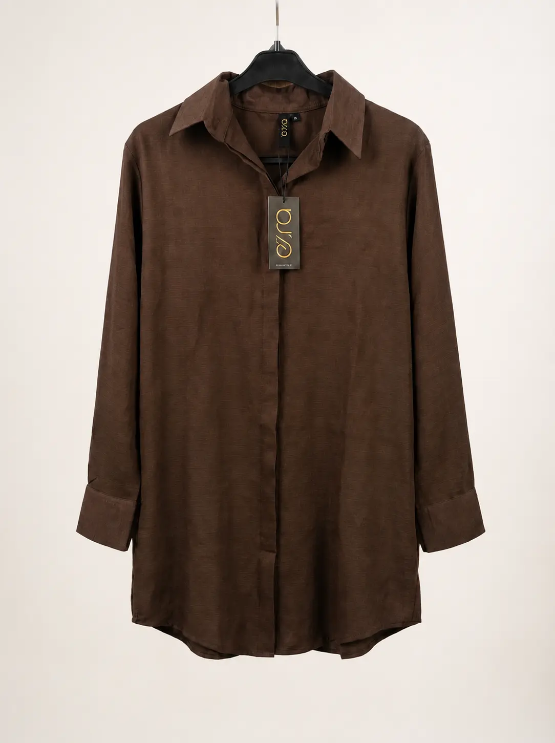 Brown long-sleeve button-down collared shirt with a brand tag hanging from the center