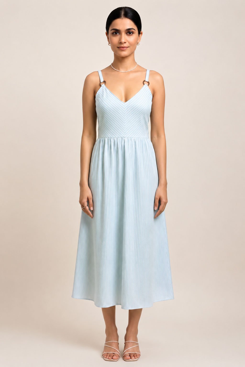 Model wearing a light blue and white striped midi sundress with ring straps and a V-neck.